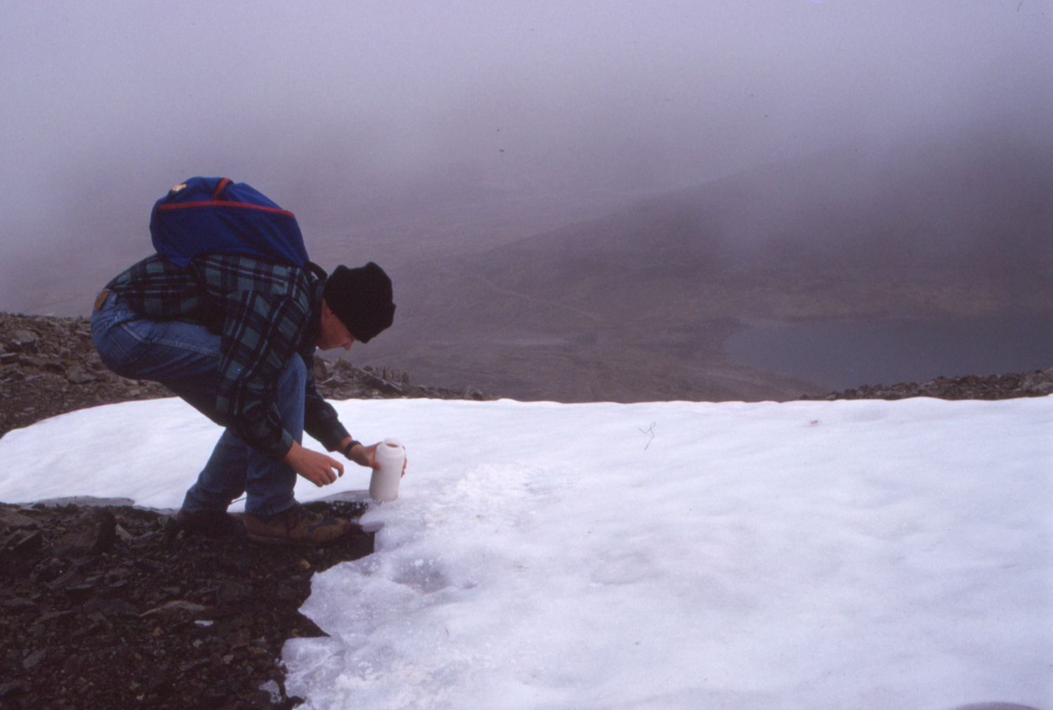 Simon fills his water bottle with snow on the way up the Peak trail on Montana Mountain.