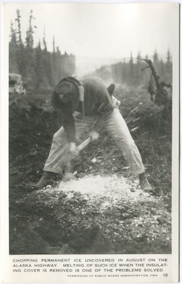 Postcard showing a man chopping frozen ground uncovered in August on the Alaska Highway in the 1940s